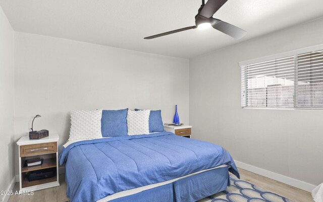 bedroom featuring ceiling fan, baseboards, and wood finished floors