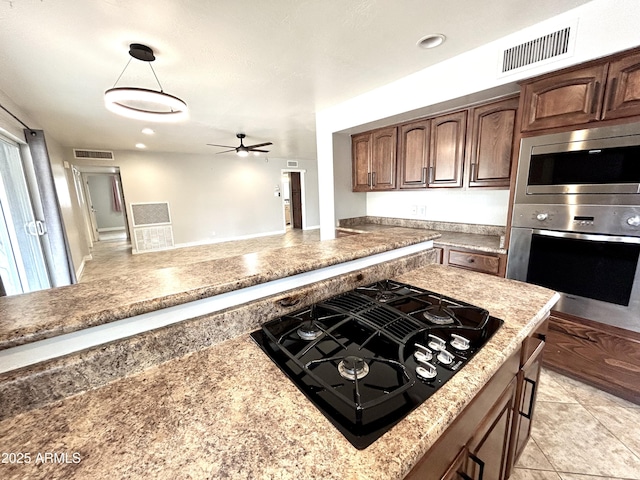 kitchen with ceiling fan, stainless steel appliances, visible vents, and light countertops