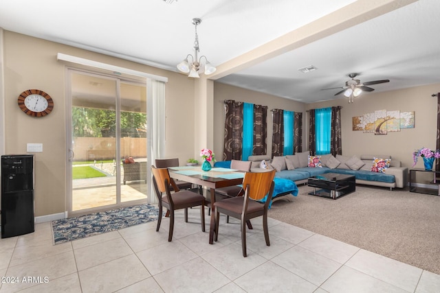 dining area with light tile patterned flooring, light colored carpet, visible vents, and ceiling fan with notable chandelier
