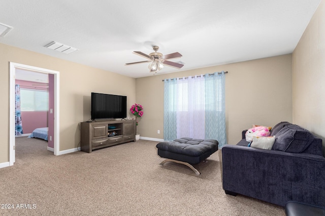 living area featuring baseboards, carpet floors, visible vents, and a ceiling fan