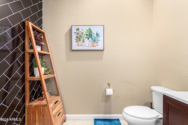 bathroom featuring baseboards, toilet, tile patterned flooring, and vanity