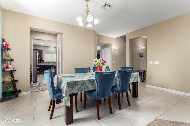 dining area with baseboards, visible vents, light tile patterned floors, and a chandelier