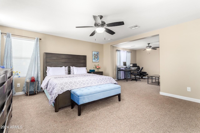 bedroom featuring baseboards, visible vents, multiple windows, and light colored carpet