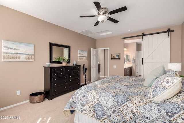 carpeted bedroom featuring a barn door, ceiling fan, and ensuite bathroom