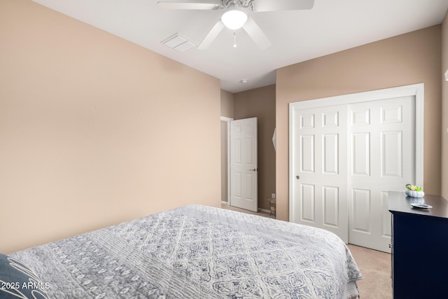 carpeted bedroom with ceiling fan and a closet