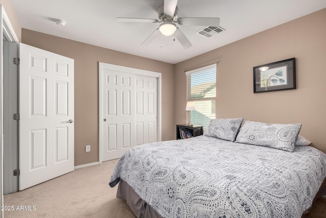 bedroom with light carpet, ceiling fan, and a closet