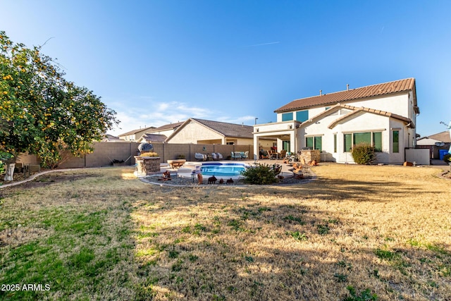 back of house with a fenced in pool, a patio, and a yard