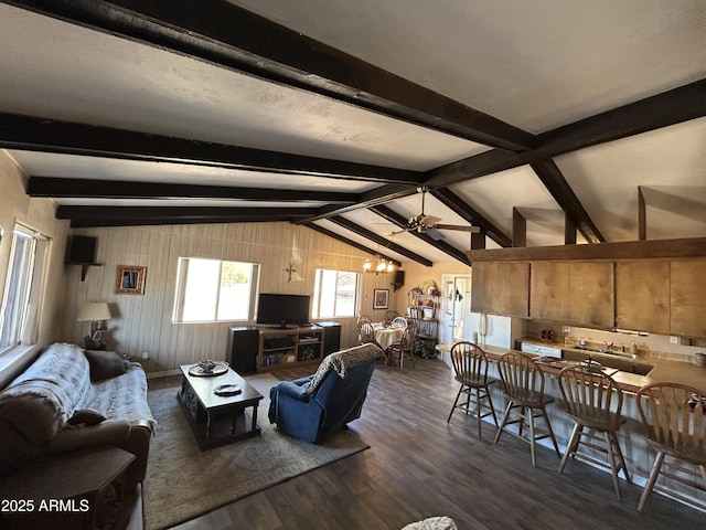 living room with dark wood-type flooring, vaulted ceiling with beams, and a ceiling fan