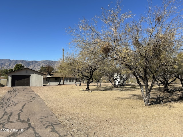 exterior space featuring driveway, an attached garage, and a mountain view