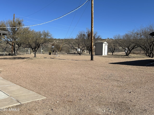 view of yard with a storage shed and an outbuilding