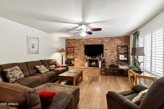 living room featuring ceiling fan, a fireplace, and light hardwood / wood-style flooring