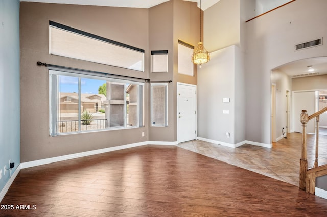 3905 S Bridal Vail Dr, Gilbert, AZ 85297 - foyer featuring arched walkways, a high ceiling, wood finished floors, and baseboards