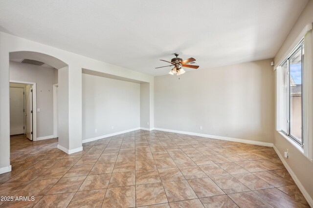 3905 S Bridal Vail Dr, Gilbert, AZ 85297 - spare room featuring a ceiling fan, arched walkways, and baseboards