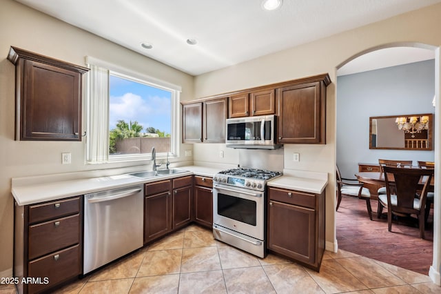 3905 S Bridal Vail Dr, Gilbert, AZ 85297 - kitchen with appliances with stainless steel finishes, a sink, light countertops, arched walkways, and a chandelier