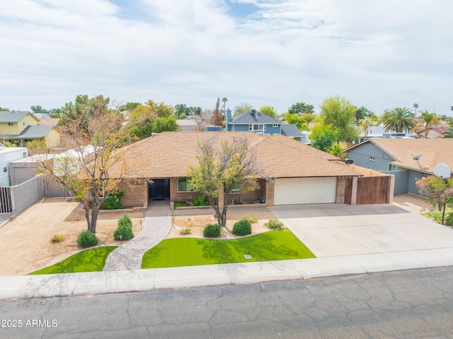 ranch-style home with a garage, brick siding, fence, driveway, and a front yard