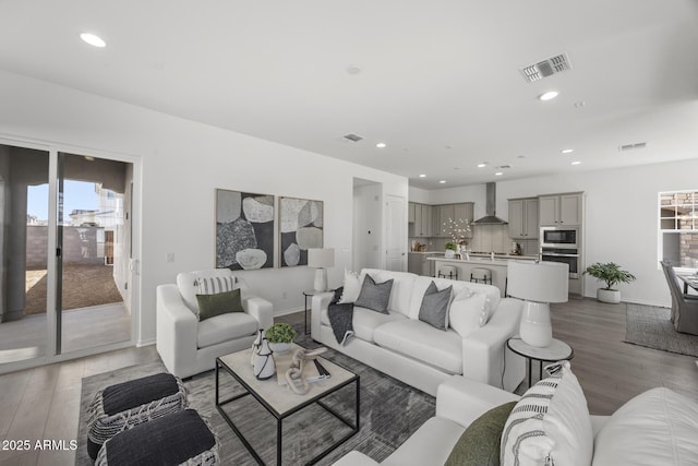 living room with recessed lighting, visible vents, and light wood-style flooring