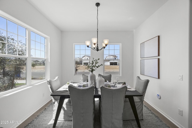 dining room with an inviting chandelier, wood finished floors, and baseboards