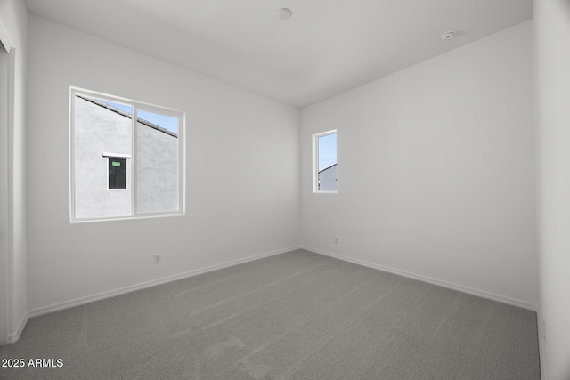 empty room with carpet and baseboards