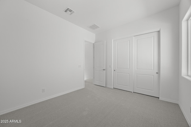 unfurnished bedroom with a closet, visible vents, baseboards, and carpet floors