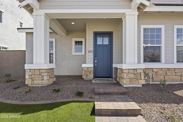 property entrance featuring stone siding and stucco siding