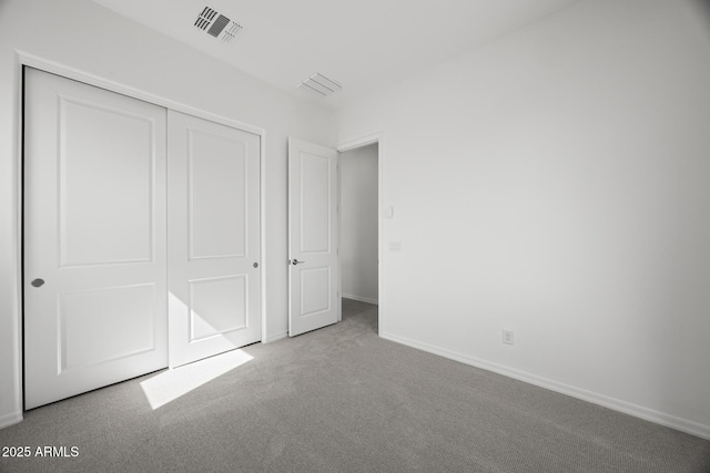 unfurnished bedroom featuring baseboards, visible vents, carpet floors, and a closet