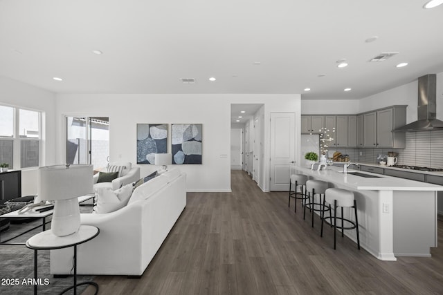 living area featuring recessed lighting, visible vents, baseboards, and dark wood finished floors