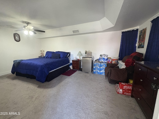 carpeted bedroom with ceiling fan, a textured ceiling, and a tray ceiling