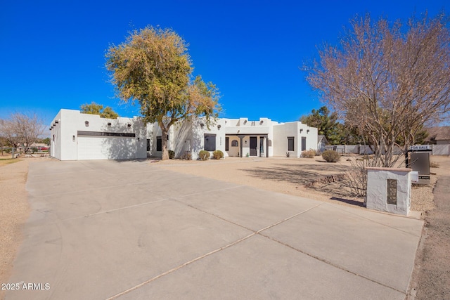 southwest-style home with driveway, an attached garage, and stucco siding