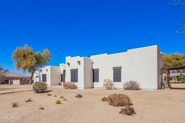 pueblo revival-style home featuring stucco siding