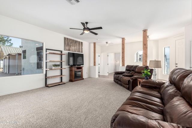 carpeted living room with visible vents, plenty of natural light, ornate columns, and ceiling fan