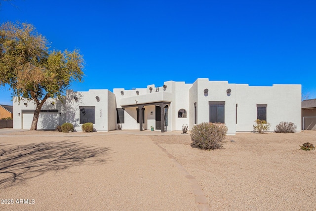 pueblo-style house featuring stucco siding