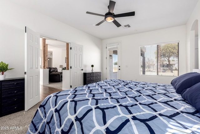 bedroom featuring arched walkways, visible vents, and ceiling fan