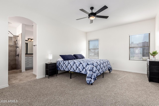 bedroom featuring arched walkways, carpet flooring, ceiling fan, and baseboards