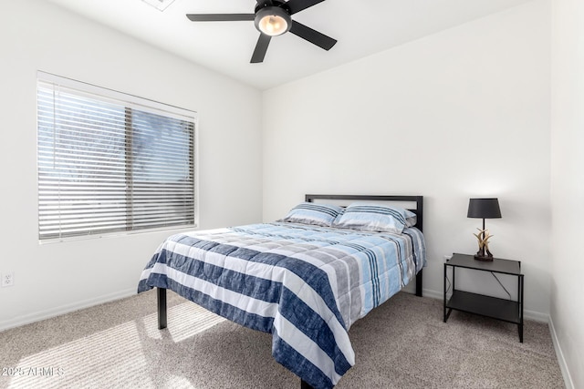 carpeted bedroom with ceiling fan and baseboards