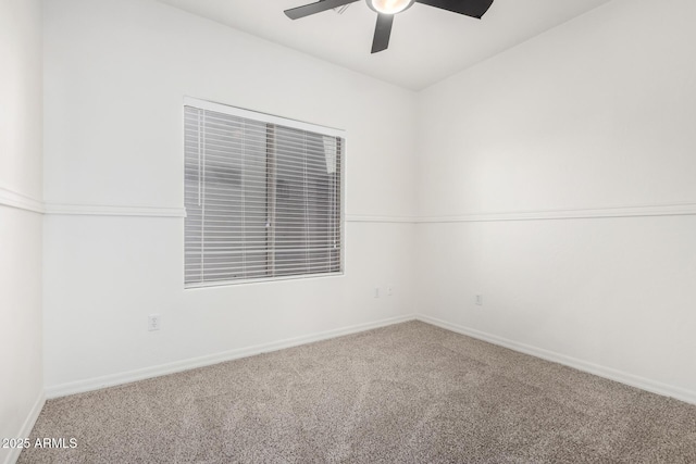 carpeted spare room featuring ceiling fan and baseboards