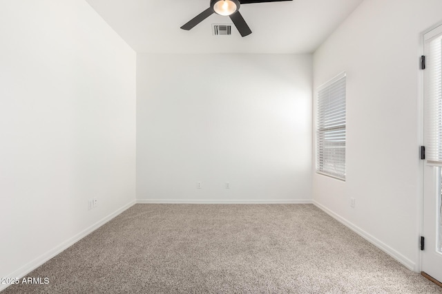 spare room featuring baseboards, carpet floors, visible vents, and a ceiling fan