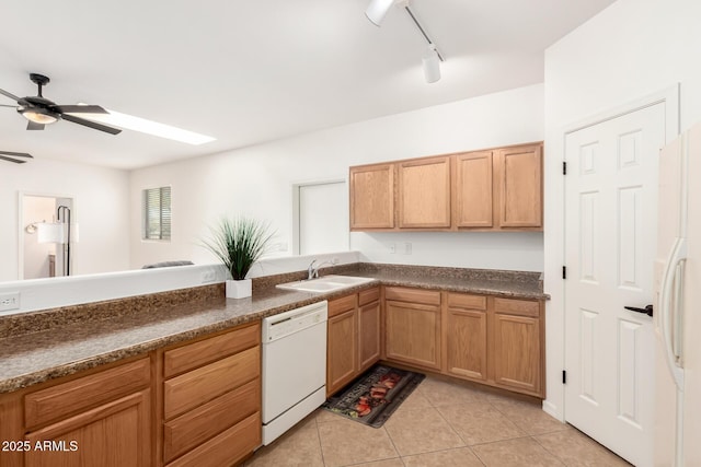 kitchen with light tile patterned floors, white appliances, a sink, a ceiling fan, and dark countertops