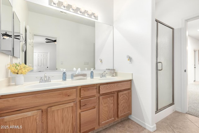 bathroom featuring a stall shower, tile patterned flooring, a sink, and double vanity