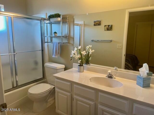 full bathroom featuring enclosed tub / shower combo, toilet, vanity, and tile patterned flooring