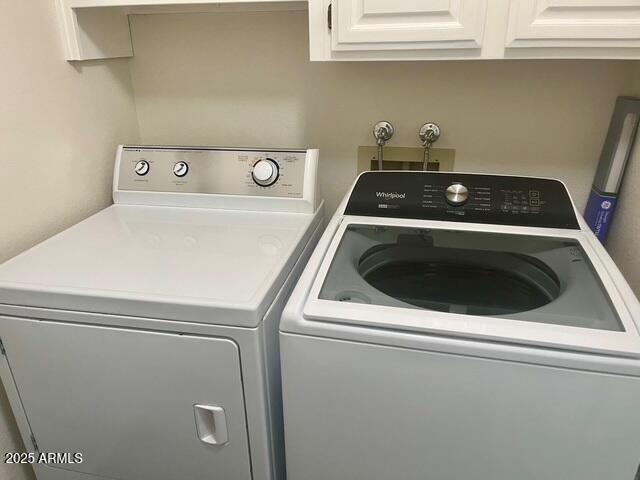 clothes washing area with cabinet space and separate washer and dryer