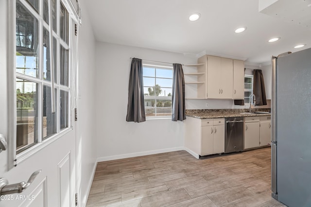 kitchen with stainless steel appliances, dark stone counters, and sink