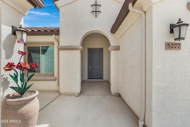 view of exterior entry with a patio area