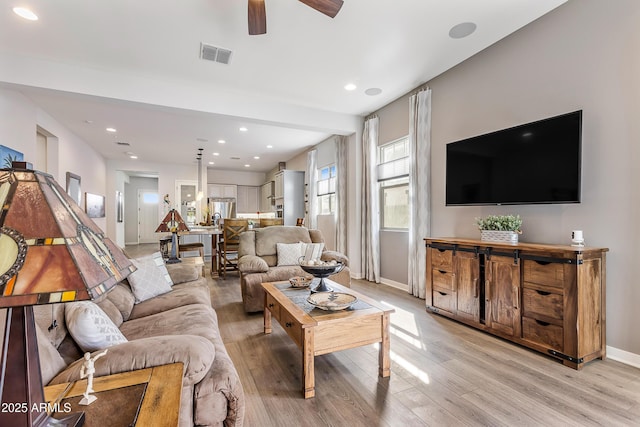 living room with light wood-type flooring, baseboards, visible vents, and recessed lighting