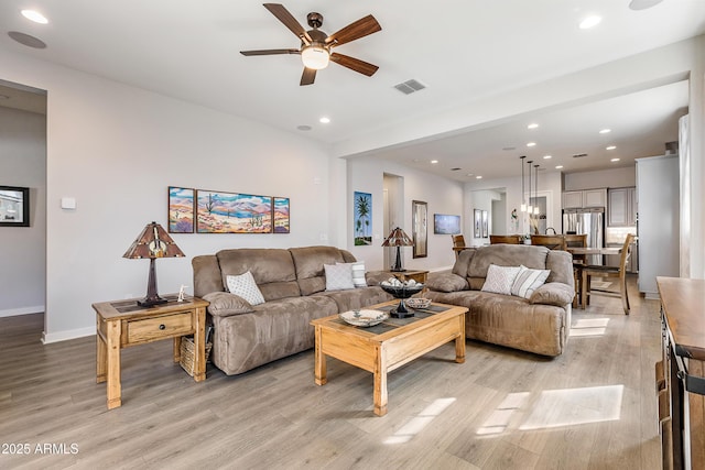 living area with recessed lighting, baseboards, visible vents, and light wood finished floors