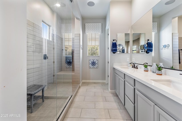 full bathroom featuring tile patterned floors, baseboards, a sink, and tiled shower