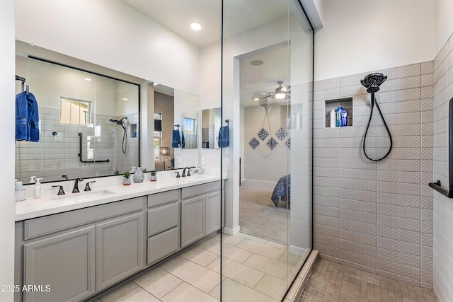 full bath featuring double vanity, ceiling fan, tile patterned floors, walk in shower, and a sink