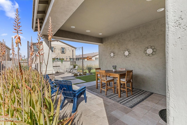 view of patio with fence and outdoor dining space