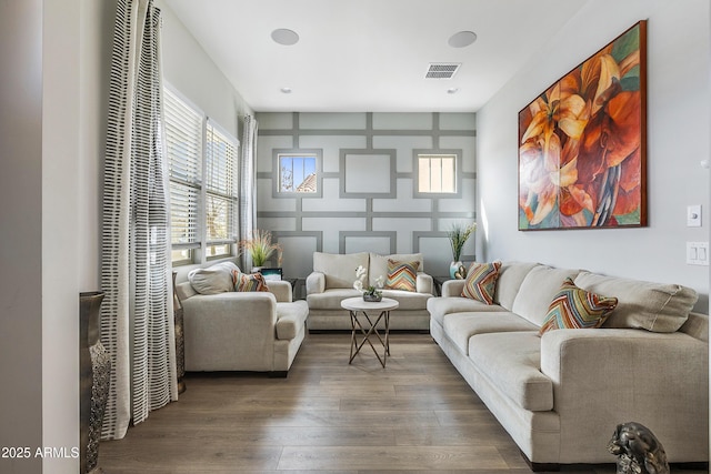 living area with visible vents and wood finished floors