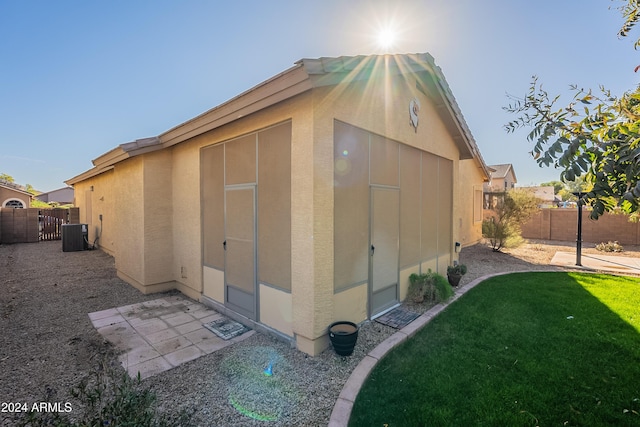 view of outbuilding with a lawn and cooling unit