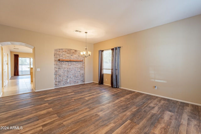 empty room featuring dark hardwood / wood-style flooring and a chandelier